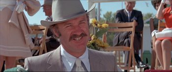 Movie still from “Prime Cut” (1972), directed by Michael Ritchie – A person wearing a suit and a cowboy hat; Close Up shot, Low angle