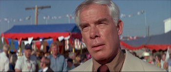 Movie still from “Prime Cut” (1972), directed by Michael Ritchie – An older man in a white suit and red neck tie; Close Up shot, Low angle
