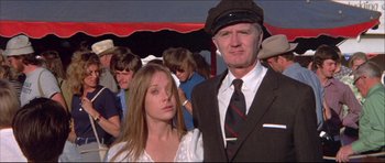 Movie still from “Prime Cut” (1972), directed by Michael Ritchie – A man and a woman standing next to each other in a crowd; Medium shot, Low angle