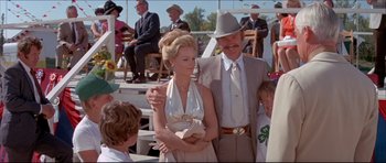 Movie still from “Prime Cut” (1972), directed by Michael Ritchie – A man and a woman standing next to each other in front of a crowd; Medium shot, Over the shoulder angle