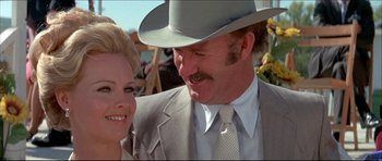 Movie still from “Prime Cut” (1972), directed by Michael Ritchie – A man and a woman wearing suits and a hat; Close Up shot, Low angle