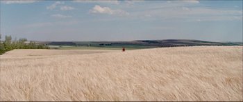 Movie still from “Prime Cut” (1972), directed by Michael Ritchie – A tractor in the middle of a wheat field; Extreme Wide shot, Over the shoulder angle