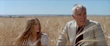 Movie still from “Prime Cut” (1972), directed by Michael Ritchie – An older man and a young girl in a field; Medium shot, Low angle