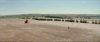 Movie still from “Prime Cut” (1972), directed by Michael Ritchie – An aerial view of an open field with a person flying a kite in the distance; Extreme Wide shot, High angle