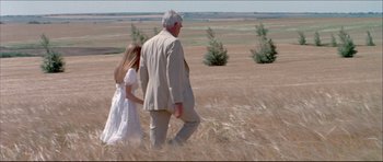 Movie still from “Prime Cut” (1972), directed by Michael Ritchie – An older man and a young girl walking through a field; Wide shot, High angle