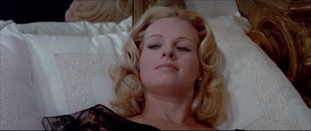 Movie still from “Prime Cut” (1972), directed by Michael Ritchie – A woman laying on a bed in a black dress; Close Up shot, Low angle