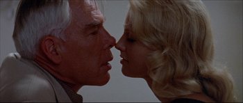 Movie still from “Prime Cut” (1972), directed by Michael Ritchie – A man and a woman face to face in front of a white wall; Close Up shot, Low angle