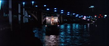 Movie still from “Prime Cut” (1972), directed by Michael Ritchie – A boat traveling down a river at night time; Extreme Wide shot, Low angle