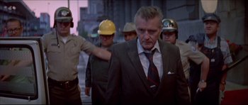Movie still from “Prime Cut” (1972), directed by Michael Ritchie – A group of men in suits and hard hats on a city street; Medium shot, Low angle