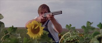 Movie still from “Prime Cut” (1972), directed by Michael Ritchie – A man holding a gun in his hands; Medium shot, Low angle