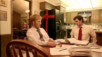Movie still from “Primer” (2004), directed by Shane Carruth – Two men sitting at a table in front of papers; Medium shot, Over the shoulder angle