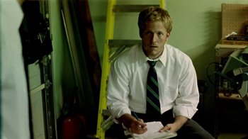 Movie still from “Primer” (2004), directed by Shane Carruth – A man sitting on a chair in front of a ladder; Medium shot, Low angle