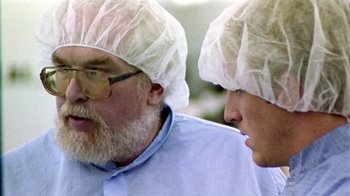 Movie still from “Primer” (2004), directed by Shane Carruth – A man with a beard and a man with a beard and a man with a hat; Close Up shot, Over the shoulder angle