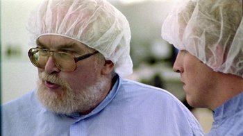 Movie still from “Primer” (2004), directed by Shane Carruth – A man with a beard wearing a head covering; Close Up shot, Over the shoulder angle