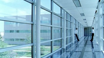 Movie still from “Primer” (2004), directed by Shane Carruth – A man standing in front of a large window; Extreme Wide shot, Low angle
