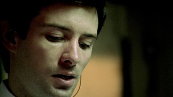 Movie still from “Primer” (2004), directed by Shane Carruth – A person wearing a headset; Extreme Close Up shot, Low angle