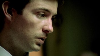 Movie still from “Primer” (2004), directed by Shane Carruth – A man's face in a dark room; Extreme Close Up shot, Low angle