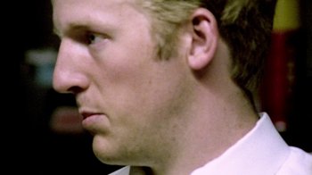 Movie still from “Primer” (2004), directed by Shane Carruth – A man's face with blonde hair; Extreme Close Up shot, Low angle