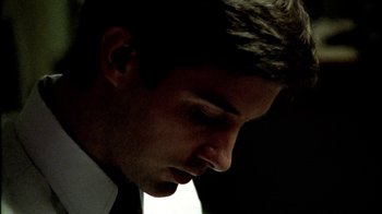 Movie still from “Primer” (2004), directed by Shane Carruth – A person wearing a suit and tie; Close Up shot, Low angle