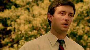 Movie still from “Primer” (2004), directed by Shane Carruth – A man wearing a shirt and a tie looking to his left; Close Up shot, Low angle