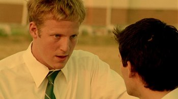 Movie still from “Primer” (2004), directed by Shane Carruth – A man wearing a green tie talking to another man wearing a white dress shirt; Close Up shot, Over the shoulder angle