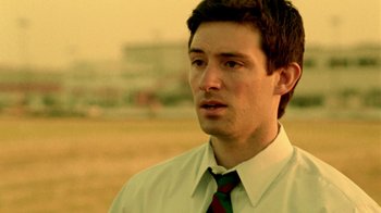 Movie still from “Primer” (2004), directed by Shane Carruth – A man wearing a white dress shirt and a green tie; Close Up shot, Low angle