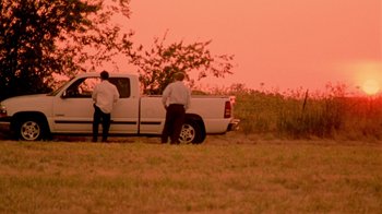 Movie still from “Primer” (2004), directed by Shane Carruth – Two men standing next to a white pick - up truck; Extreme Wide shot, Low angle
