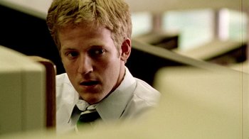Movie still from “Primer” (2004), directed by Shane Carruth – A man with blonde hair wearing a white shirt and a green tie; Close Up shot, Low angle