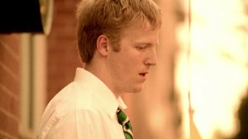 Movie still from “Primer” (2004), directed by Shane Carruth – A young man wearing a white shirt and a green tie; Close Up shot, Low angle