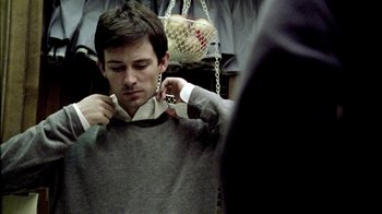 Movie still from “Primer” (2004), directed by Shane Carruth – A young man is fixing his tie in the mirror; Close Up shot, Over the shoulder angle