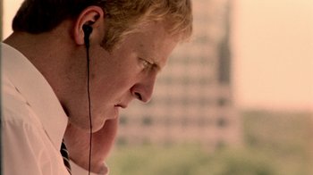 Movie still from “Primer” (2004), directed by Shane Carruth – A young man wearing a pair of ear buds; Close Up shot, Low angle