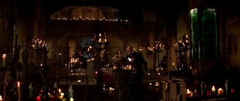 Movie still from “Prince of Darkness” (1987), directed by John Carpenter – A man and a woman standing in front of candles; Wide shot, High angle