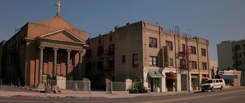Movie still from “Prince of Darkness” (1987), directed by John Carpenter – A building with a fire hydrant on the side of the street; Extreme Wide shot, Low angle