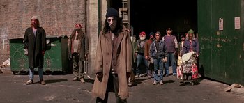 Movie still from “Prince of Darkness” (1987), directed by John Carpenter – A group of people standing in a street; Wide shot, High angle