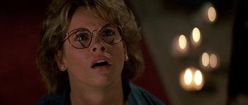 Movie still from “Prince of Darkness” (1987), directed by John Carpenter – A person wearing glasses; Close Up shot, Over the shoulder angle