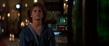 Movie still from “Prince of Darkness” (1987), directed by John Carpenter – A man standing next to a camera in a dark room; Close Up shot, Low angle