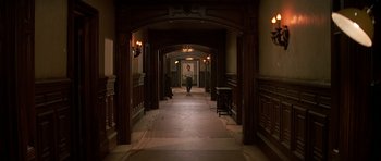 Movie still from “Prince of Darkness” (1987), directed by John Carpenter – A person walking down a long hallway in a building; Wide shot, High angle