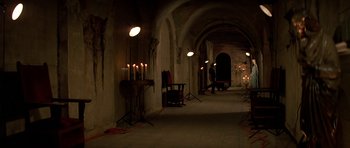 Movie still from “Prince of Darkness” (1987), directed by John Carpenter – Candles lit in an archway in an old building; Extreme Wide shot, High angle