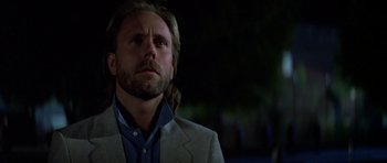 Movie still from “Prince of Darkness” (1987), directed by John Carpenter – A person wearing a suit and tie; Close Up shot, Low angle