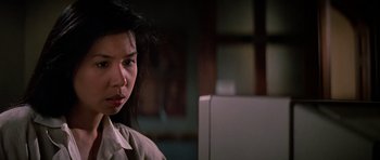 Movie still from “Prince of Darkness” (1987), directed by John Carpenter – A young woman is standing in front of a computer; Close Up shot, Low angle