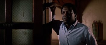 Movie still from “Prince of Darkness” (1987), directed by John Carpenter – A man leaning against a wall in a dark room; Close Up shot, Low angle