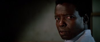 Movie still from “Prince of Darkness” (1987), directed by John Carpenter – A man's face in a dark room; Close Up shot, Low angle