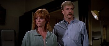 Movie still from “Prince of Darkness” (1987), directed by John Carpenter – A man and a woman standing next to each other; Close Up shot, Low angle