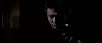 Movie still from “Prince of Darkness” (1987), directed by John Carpenter – A man in a dark room looking down at the ground; Close Up shot, Low angle