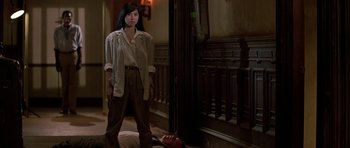 Movie still from “Prince of Darkness” (1987), directed by John Carpenter – A woman standing next to a man laying on the ground; Wide shot, Low angle