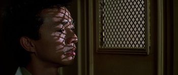 Movie still from “Prince of Darkness” (1987), directed by John Carpenter – A person with a shadow of their face on a wall; Close Up shot, Low angle