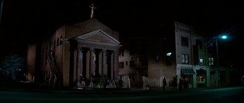 Movie still from “Prince of Darkness” (1987), directed by John Carpenter – People walking in front of a building at night; Extreme Wide shot, Low angle