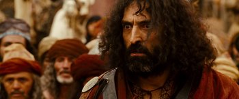Movie still from “Prince of Persia: The Sands of Time” (2010), directed by Mike Newell – A man with long hair and a beard stares at the camera; Close Up shot, Over the shoulder angle
