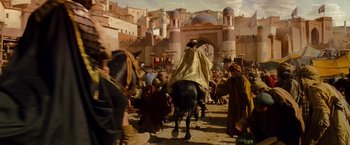Movie still from “Prince of Persia: The Sands of Time” (2010), directed by Mike Newell – A group of people walking down a street on horses; Extreme Wide shot, Over the shoulder angle