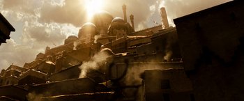 Movie still from “Prince of Persia: The Sands of Time” (2010), directed by Mike Newell – The sun is shining over a building with smoke coming out of it; Extreme Wide shot, Low angle